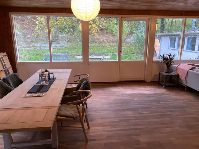 Langt spisebord ved store vinduer med papirlamper