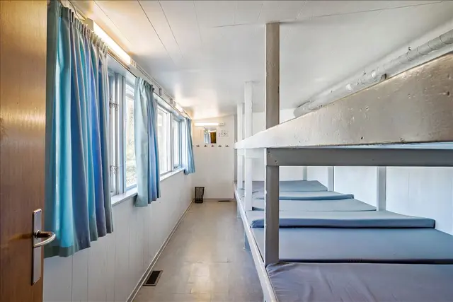 Lang sovesal med køjepladser langs vinduerne